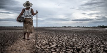 women standing dry soil fishing gear global warming water crisis