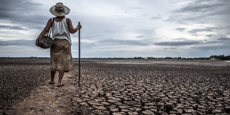 women standing dry soil fishing gear global warming water crisis